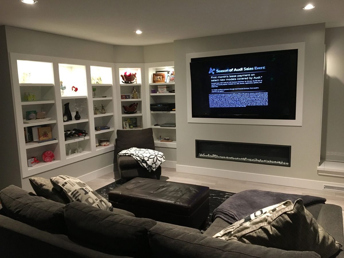 TV built into a shelving wall above a linear fireplace