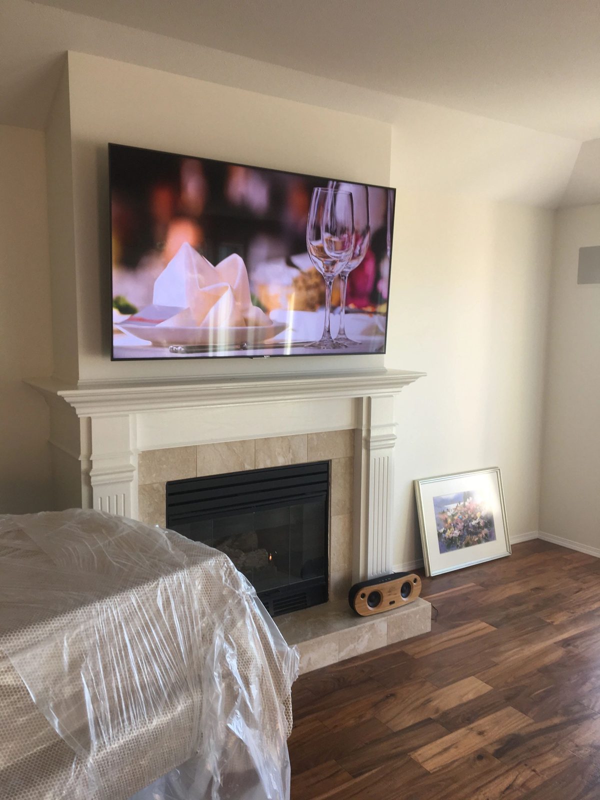 TV mounted above a fireplace in a bedroom
