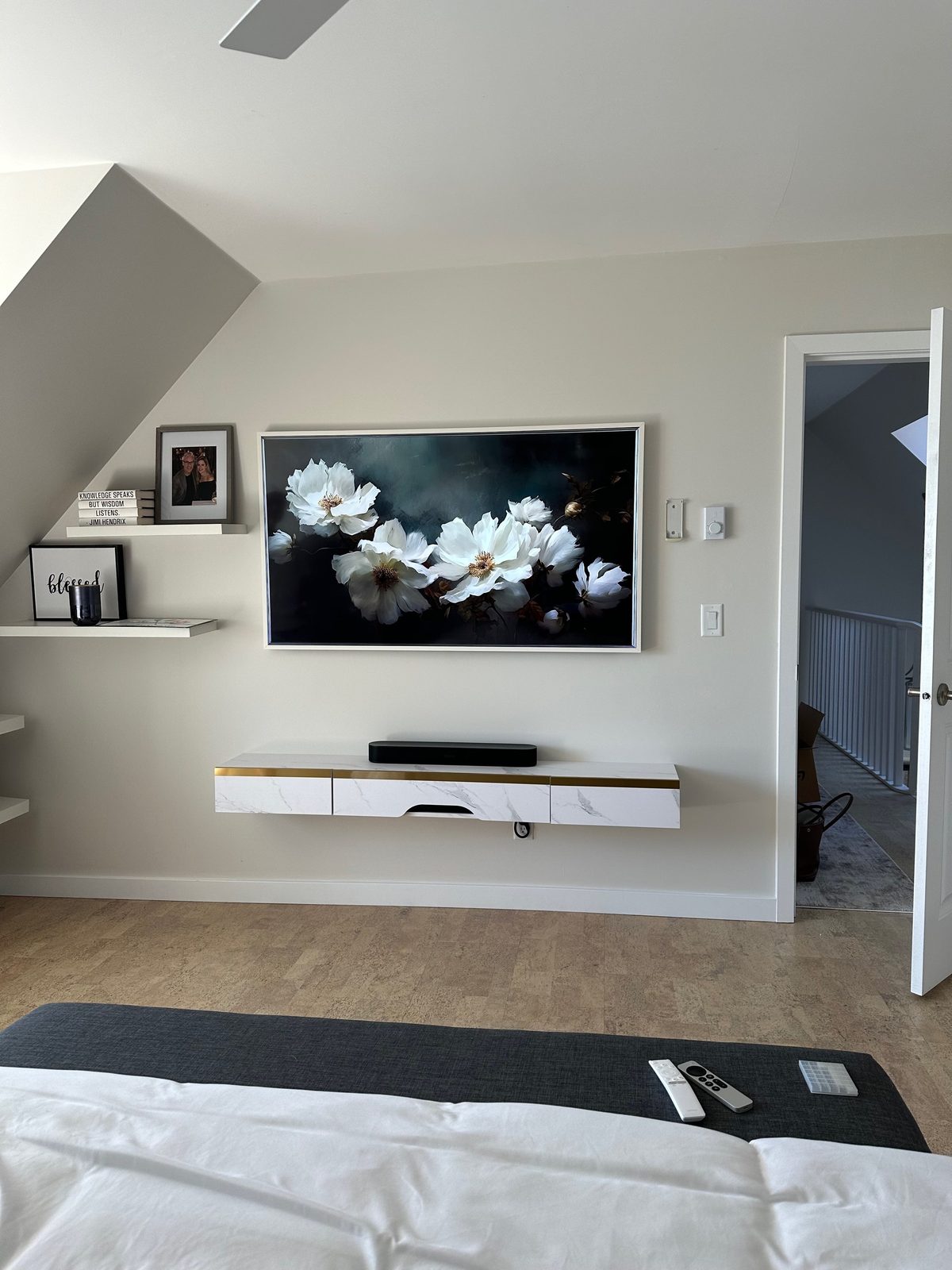 Frame TV mounted in a bedroom above a floating marble and brass console