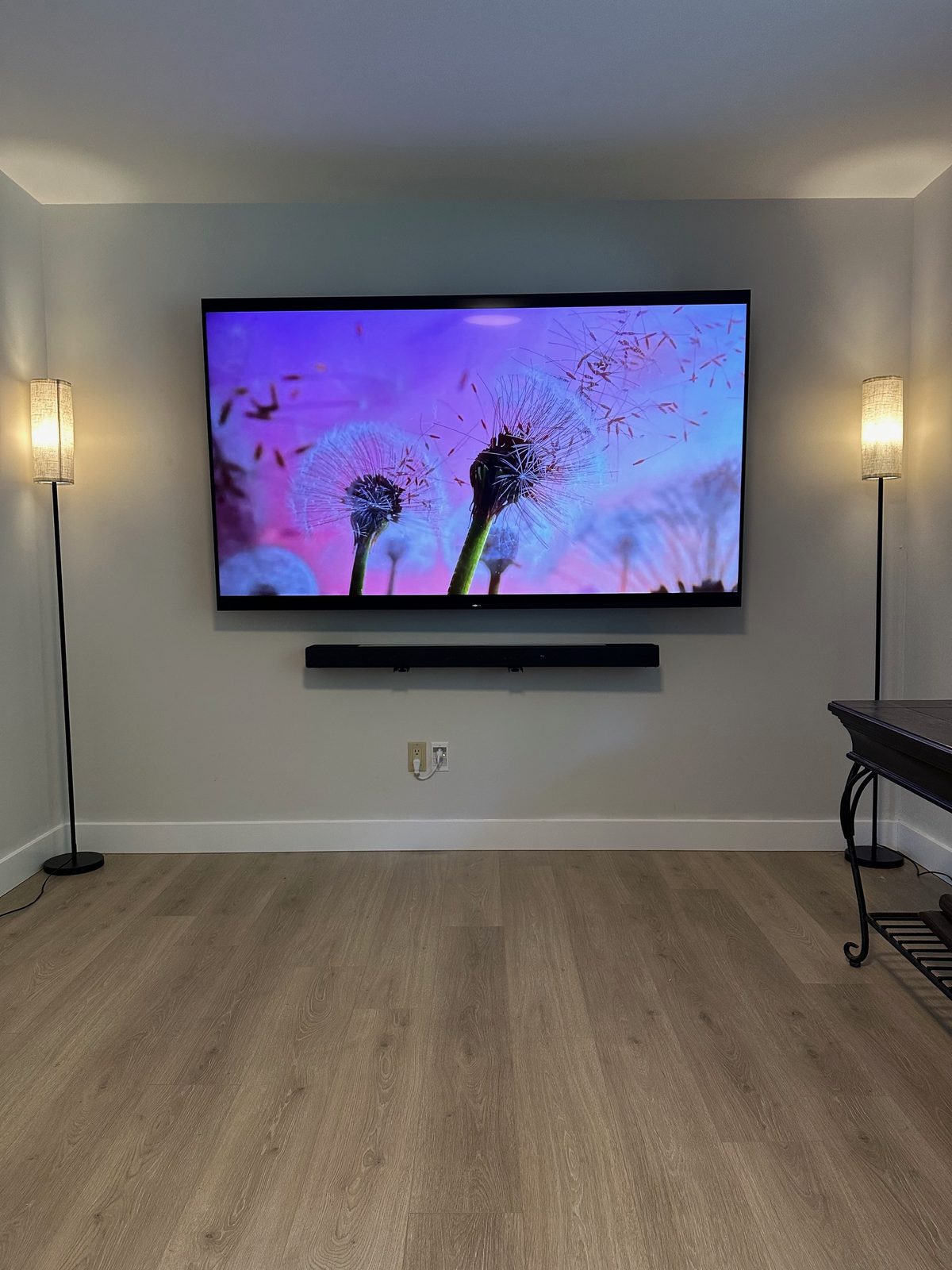 TV and wall mounted soundbar centred between matching floor lamps