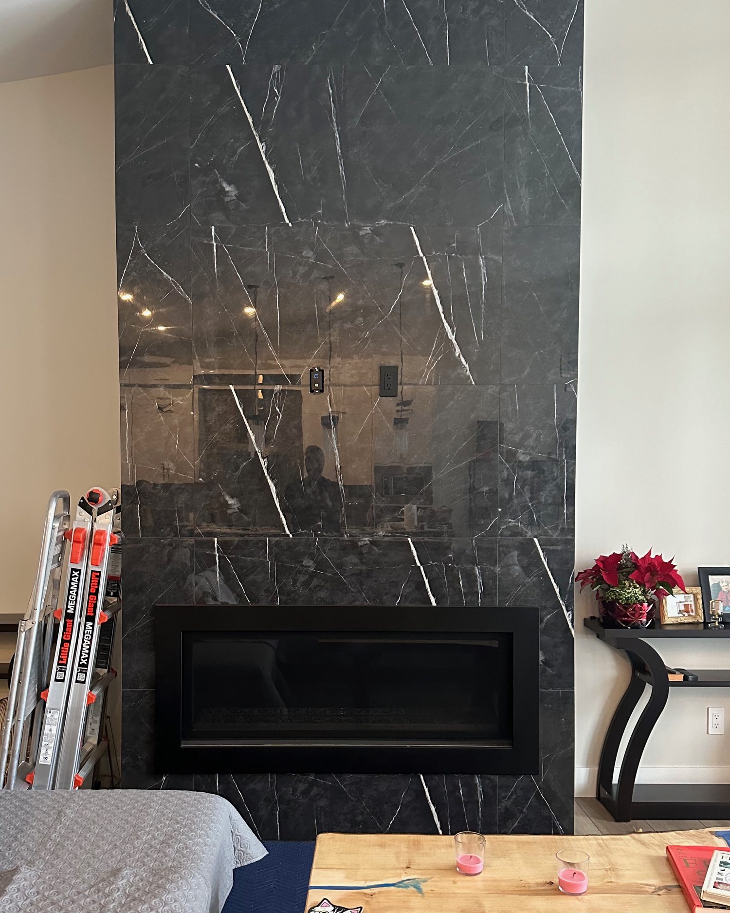 Bare black marble fireplace wall with only the recessed plates set