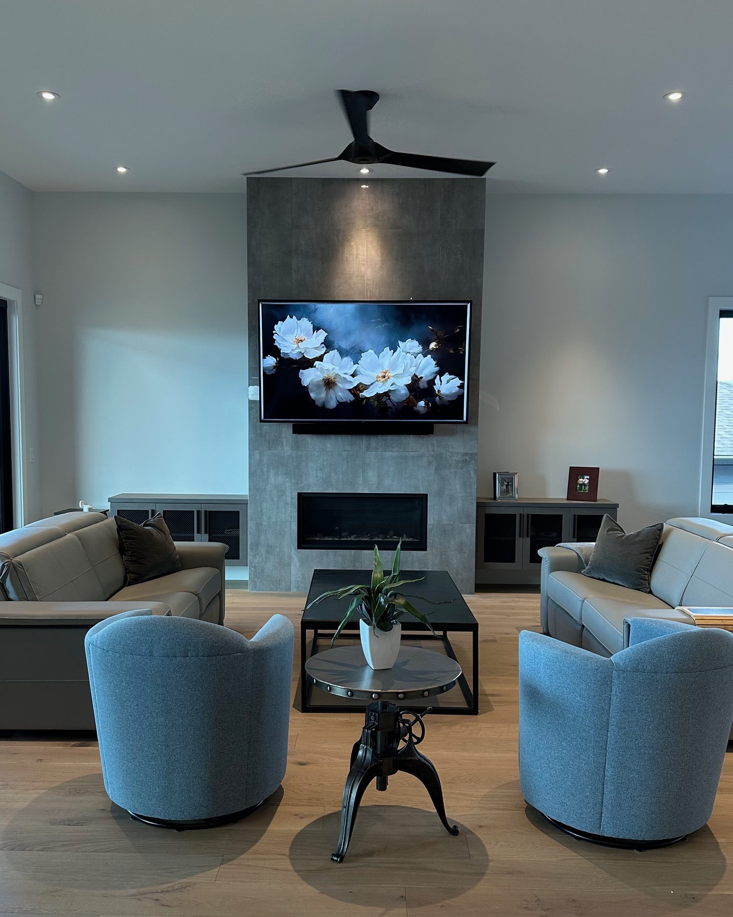 TV and soundbar mounted flush on the porcelain-tile fireplace wall in Kelowna, with no visible cables