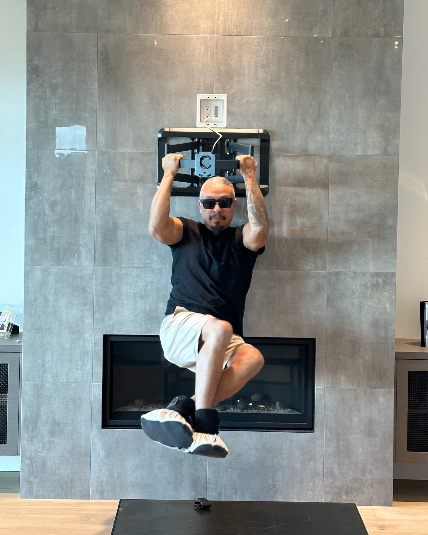 Wil Martinez hanging his full body weight from the wall mount he anchored to the porcelain-tile fireplace wall