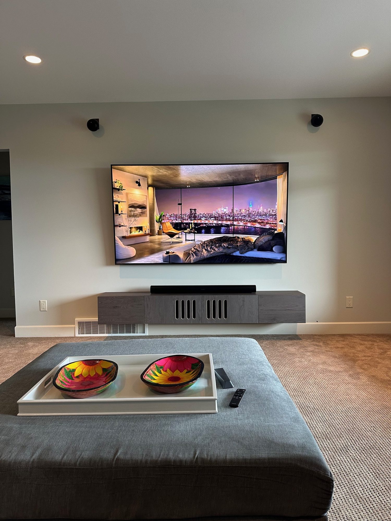 Sonos Arc soundbar with on-wall surround speakers flanking a wall mounted TV