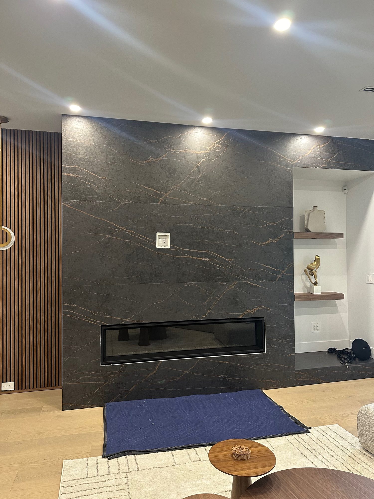 Recessed in-wall media box set into a porcelain slab feature wall before the TV goes on